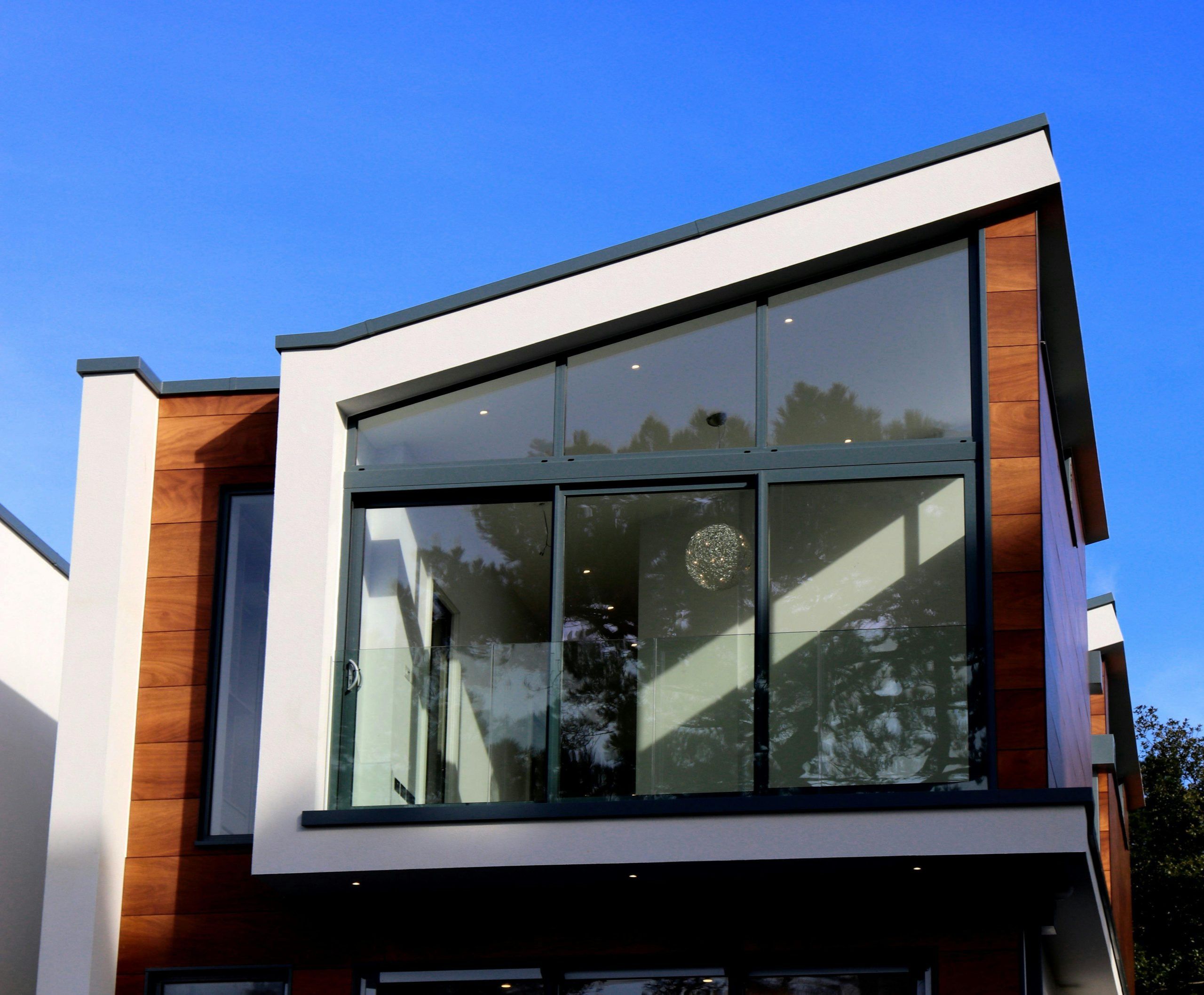 Modern huis met grote ramen en houten afwerking.